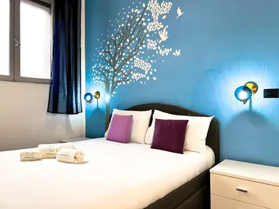 a bedroom with a bed with a blue wall at UNIQUE House - 3 Bedrooms & 2 Bathrooms with 4 Beds - 100 meters to the Metro A in Rome