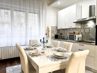 a white kitchen with a dining table and chairs at UNIQUE House - 3 Bedrooms & 2 Bathrooms with 4 Beds - 100 meters to the Metro A in Rome