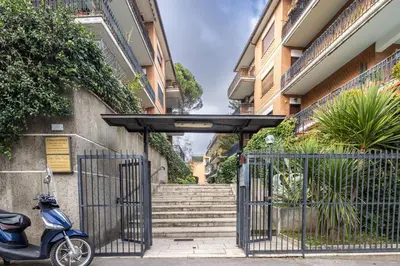 a scooter parked in front of a gate with stairs at Garden House by BuddyRent in Rome