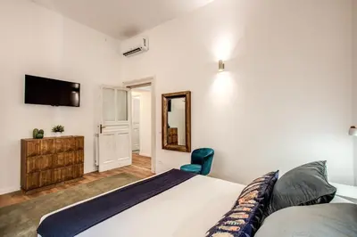 a bedroom with a large bed and a mirror at MONTI QUIET AND SPACIOUS APARTMENT in Rome