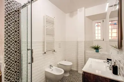 a white bathroom with a toilet and a sink at MONTI QUIET AND SPACIOUS APARTMENT in Rome