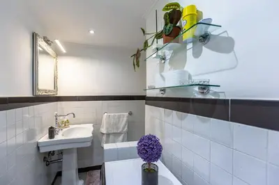 a white bathroom with a sink and a toilet at Gianicolo Holiday House in Rome