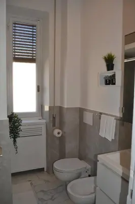 a white bathroom with a toilet and a window at Maison Coco' in Rome in Rome