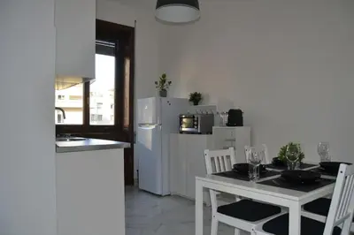 a kitchen with a table and a white refrigerator at Maison Coco' in Rome in Rome