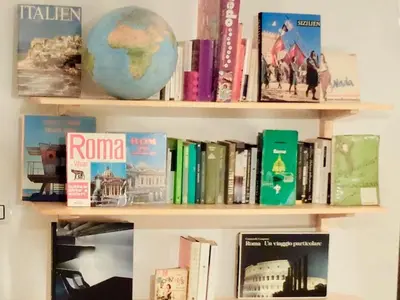 a book shelf with books and a globe on it at Vintage in Trastevere in Rome
