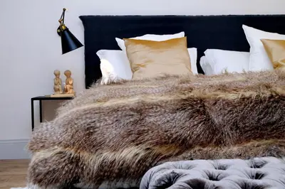 a bed with a furry blanket on it with pillows at Luxury Charme between Pantheon and Spanish Steps in Rome