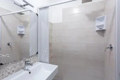 a white bathroom with a sink and a mirror at Hotel Cathrine in Rome