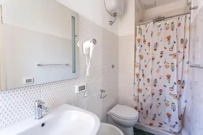 a bathroom with a sink and a toilet and a shower curtain at Hotel Cathrine in Rome