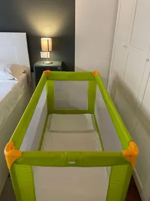 a green chair in a room with a bed at Panoramic Flat Barberini in Rome