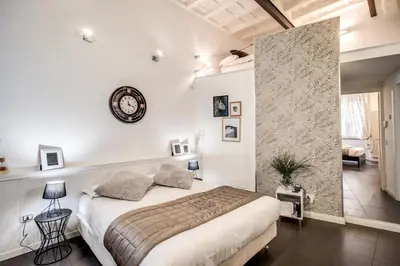 a bedroom with a bed and a clock on the wall at Trastevere Miracle Suite in Rome