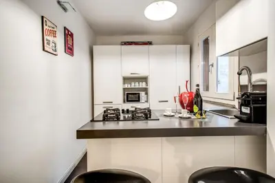 a kitchen with white cabinets and a counter top at Trastevere Miracle Suite in Rome