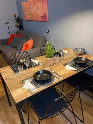 a wooden table with plates and bowls on top of it at Tolemaide Orange Apartment in Rome