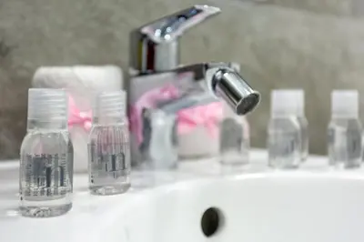 a bathroom sink with glass bottles and a faucet at A casa di Elly 2 in Rome