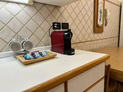 a kitchen counter with a coffee maker and cups at San Pietro city center close to the subway in Rome