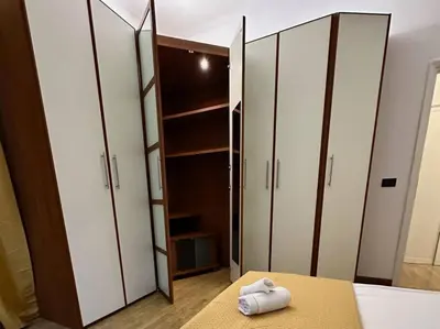 a bedroom with white cabinets and a bed with towels at San Pietro city center close to the subway in Rome
