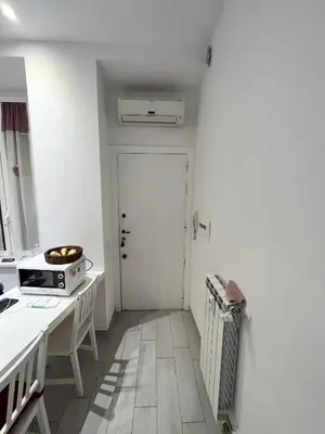 a kitchen with a white door and a microwave at Cuore di Testaccio Apartment 2 in Rome