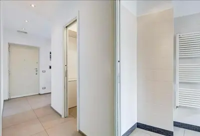a hallway with white walls and a mirror at Domus Testaccio in Rome