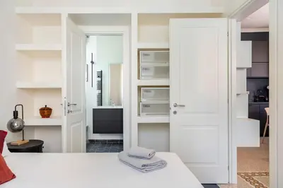a white room with a bed and a bathroom at Your Cozy Home in Rome- Gemelli- close to downtown in Rome