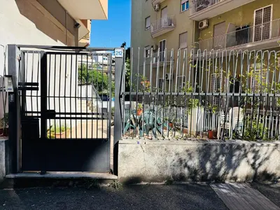 a gate with a dog sitting in front of a building at Pamphili212 in Rome