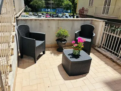 a patio with two chairs and a table with flowers at Pamphili212 in Rome