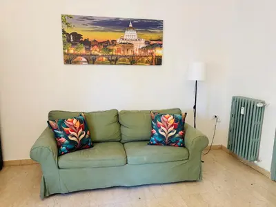 a green couch in a living room with a painting on the wall at Pamphili212 in Rome