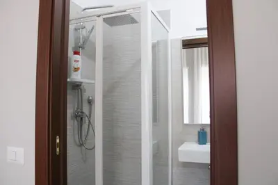 a bathroom with a glass shower with a sink at Villa Bonelli Dreams in Rome in Rome