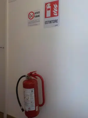 a fire hydrant on a white wall with a sign at Jack's House - Tourist Rentals - in Rome