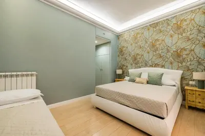 a bedroom with a white bed and a wall mural at Grande e storico appartamento ai Musei Vaticani in Rome