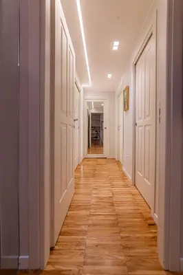 a hallway with white doors and a wooden floor at Domus Rea - Vaticano - Metro Baldo degli Ubaldi in Rome