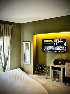 a bedroom with a bed and a television on the wall at Trastevere House B&B in Rome