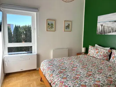 a bedroom with a bed and a green wall at Aurelia House Garden in Rome