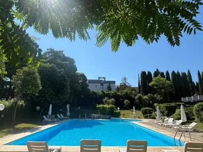 a swimming pool in a resort with chairs and trees at Aurelia House Garden in Rome