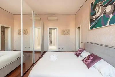 a bedroom with two beds and a painting on the wall at Stunning Center Rome Apartment in Rome