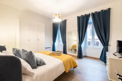 a bedroom with blue curtains and a bed at DOMUS TRAIANA in Rome