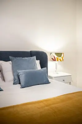 a bed with blue and white pillows and a lamp at DOMUS TRAIANA in Rome