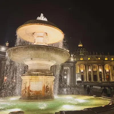 a fountain in front of a building at night at St. Peter's Balloon a due passi da San Pietro! in Rome