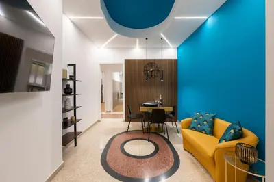a living room with a yellow couch and a table at Lifestyle Vatican Apartment in Rome