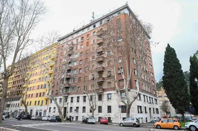 a large brick building with cars parked in front of it at Casa Angelico in Rome