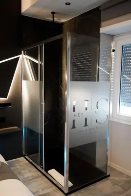 a glass shower in a room with a sign at HeySuite - Luxury House - ROMA Trastevere in Rome
