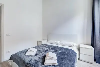 a white bedroom with a bed with towels on it at Inner House 3 in Rome