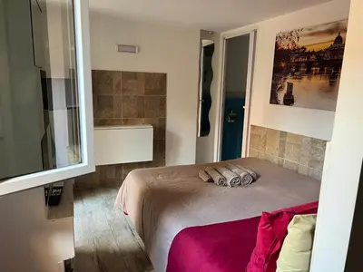 a bedroom with a bed and a large window at Monolocale Trastevere locato per finalità turistiche in Rome