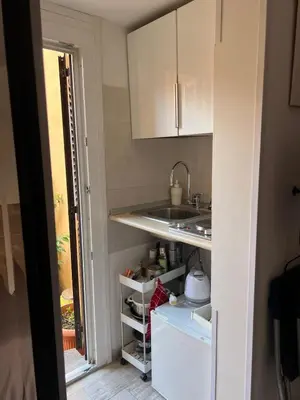 a kitchen with a sink and an open refrigerator at Monolocale Trastevere locato per finalità turistiche in Rome