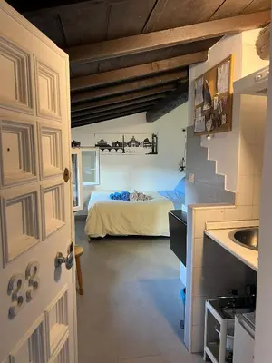 a room with a bed and a kitchen with a door at Monolocale Trastevere locato per finalità turistiche in Rome