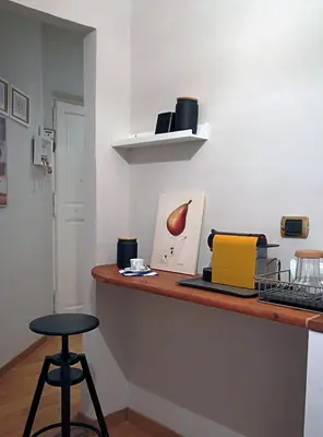 a counter with a bar with a stool and a picture at Gelso in Rome