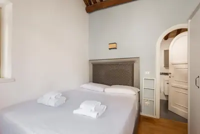 a white bedroom with two towels on a bed at Pavone Centre Romantic Apartment in Rome