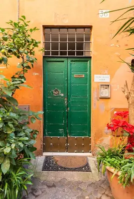 a green door on the side of a building at Pavone Centre Romantic Apartment in Rome