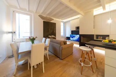 a kitchen and living room with a table and a couch at Banchi Nuovi, modern and cozy apartment in Rome