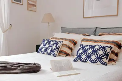 a bed with a book and pillows on it at Metastasio in Rome