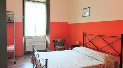 a bedroom with a bed and a red wall at Rome Near Colosseum in Rome