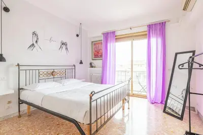 a bedroom with a bed with purple curtains at Ambra's bright apartment in Rome